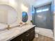 Modern bathroom featuring dual sinks, a shower over tub, gray tile, and neutral color palette at 2280 S Pampa Ave, Pahrump, NV 89048