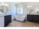 Bright bathroom featuring a modern soaking tub, dual vanity, stone accents, and neutral color palette at 2280 S Pampa Ave, Pahrump, NV 89048