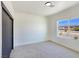 Well-lit bedroom featuring carpet flooring, a window view, and a contemporary sliding closet door at 2280 S Pampa Ave, Pahrump, NV 89048