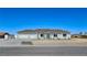View of the single-story home with a three-car garage, desert landscaping, and concrete driveway at 2280 S Pampa Ave, Pahrump, NV 89048