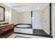 Modern bathroom featuring a soaking tub, granite counters, and a cherry vanity at 2700 Las Vegas Blvd # 3105, Las Vegas, NV 89109