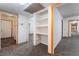 Hallway with grey carpet, built-in shelving, and doors to other rooms at 3759 Glen Ave, Las Vegas, NV 89121