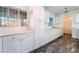 White kitchen with wood-look vinyl flooring and lots of cabinets at 3759 Glen Ave, Las Vegas, NV 89121