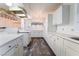 Charming kitchen featuring white cabinets, dark floors, and a decorative lighting fixture at 3759 Glen Ave, Las Vegas, NV 89121