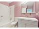 Bathroom with gray vanity, shower/tub combo and pink walls at 3766 Millwood Ave, Las Vegas, NV 89121