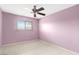 A bedroom with pale pink walls, ceiling fan, and tile floor at 3766 Millwood Ave, Las Vegas, NV 89121