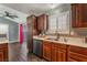 Kitchen with stainless steel dishwasher and sink, wood cabinets and vinyl flooring at 424 Sarajane Lane, Las Vegas, NV 89107