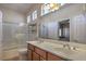 Bright bathroom featuring a double sink vanity, shower over tub, and ample lighting at 5635 Exotic Rosette Ave, Las Vegas, NV 89139