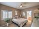 Cozy bedroom with a ceiling fan, window with shutters, and ensuite bathroom access at 5635 Exotic Rosette Ave, Las Vegas, NV 89139