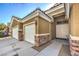 Close-up of a home with a three-car garage, stone accents, covered entry, and mature landscaping at 5635 Exotic Rosette Ave, Las Vegas, NV 89139