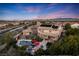 Aerial view of a two-story home with a private pool, lush landscaping, and mountain views at sunset at 5734 San Florentine Ave, Las Vegas, NV 89141