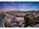 An elevated view of a landscaped yard with a pool and mountains in the distance at 5734 San Florentine Ave, Las Vegas, NV 89141