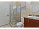 Bathroom featuring glass enclosed shower, white commode and sink basin, and cherry wood cabinetry at 5734 San Florentine Ave, Las Vegas, NV 89141