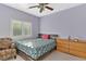 Cozy bedroom featuring a comfortable bed with floral bedding, a wooden dresser, and a ceiling fan at 5734 San Florentine Ave, Las Vegas, NV 89141