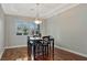 Well-lit dining room featuring hardwood floors, a modern light fixture, and white window shutters at 5734 San Florentine Ave, Las Vegas, NV 89141