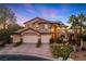 Charming two-story home boasting a three-car garage, tile roof, and manicured landscaping at dusk at 5734 San Florentine Ave, Las Vegas, NV 89141