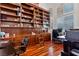 Spacious home office featuring custom bookshelves and a rolling ladder plus beautiful hardwood flooring and natural lighting at 5734 San Florentine Ave, Las Vegas, NV 89141