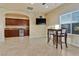 Light filled living room featuring a built-in wet bar, casual table set, and a flat screen TV at 5734 San Florentine Ave, Las Vegas, NV 89141