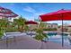 Relaxing pool and spa with lounge seating under red umbrellas with a backdrop of mature landscaping at 5734 San Florentine Ave, Las Vegas, NV 89141