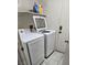 Bright laundry room featuring a washer and dryer set with tile floors and shelf storage at 6296 Peach Orchard Rd, Las Vegas, NV 89142