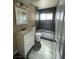 Modern bathroom featuring gray tile, bright natural light, and a white vanity at 7237 William Anders Ave, Las Vegas, NV 89145