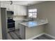 Stylish kitchen featuring white cabinets, quartz countertops, stainless steel appliances, and modern flooring at 7237 William Anders Ave, Las Vegas, NV 89145