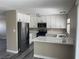 Stylish kitchen featuring white cabinets, quartz countertops, stainless steel appliances, and modern flooring at 7237 William Anders Ave, Las Vegas, NV 89145