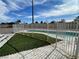 Backyard with a fenced kidney-shaped pool with white brick coping and artificial turf at 7237 William Anders Ave, Las Vegas, NV 89145