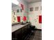 Bathroom with a black vanity, black toilet, black tile floors, and red towels at 7415 Constantinople Ave, Las Vegas, NV 89129