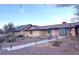 Tan single story home featuring a brown roof, desert landscaping, and an attractive trellis at 7415 Constantinople Ave, Las Vegas, NV 89129