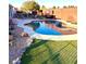 Relax in this backyard oasis complete with artificial turf, a swimming pool, and a tranquil waterfall feature at 7415 Constantinople Ave, Las Vegas, NV 89129