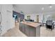 Modern kitchen island with a wood countertop, view into the living and dining areas at 8044 Edward Baher Ave, Las Vegas, NV 89149