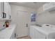 Bright laundry room featuring washer, dryer, and utility sink at 8044 Edward Baher Ave, Las Vegas, NV 89149