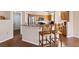 Kitchen island with granite countertop and two barstools at 8212 Bolingbrook Ave, Las Vegas, NV 89149