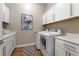 Laundry room with washer, dryer, and white cabinets at 8750 Lutts St, Las Vegas, NV 89131