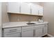 Laundry room with white cabinets, a countertop sink, and wooden floors at 8750 Lutts St, Las Vegas, NV 89131