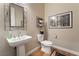 Elegant powder room with a pedestal sink, toilet, and framed art at 8750 Lutts St, Las Vegas, NV 89131