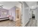 Spacious bedroom with light purple walls, a comfortable bed, and wood-look flooring at 9330 Golden Timber Ln, Las Vegas, NV 89117