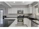 Modern kitchen with white cabinets, granite countertops, and stainless steel appliances at 9330 Golden Timber Ln, Las Vegas, NV 89117