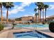 Community pool and spa with lounge chairs and lush landscaping at 9330 Golden Timber Ln, Las Vegas, NV 89117