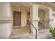 Small front porch with two red chairs and a dark brown door at 947 Cantabria Heights Ave, Las Vegas, NV 89183