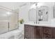 Well-lit bathroom featuring a shower-tub combo with sliding glass doors and a dark wood vanity with a white countertop at 99 Teton Pines Dr, Henderson, NV 89074