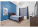 Bedroom featuring a large window with curtains, carpet flooring, and a blue accent wall at 99 Teton Pines Dr, Henderson, NV 89074