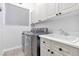 Laundry room equipped with a front-load washer and dryer, as well as a utility sink at 99 Teton Pines Dr, Henderson, NV 89074