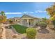 Backyard with rock landscaping, artificial grass, a covered patio, and mature landscaping at 10282 Country Flats Ln, Las Vegas, NV 89135