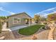 Green backyard with covered patio, gravel, and manicured lawn at 10282 Country Flats Ln, Las Vegas, NV 89135