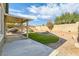 Backyard area featuring a covered patio, artificial grass, and rock landscaping at 10282 Country Flats Ln, Las Vegas, NV 89135