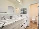 Modern bathroom features double sink vanity with granite countertops, large mirror, and tile flooring at 10282 Country Flats Ln, Las Vegas, NV 89135