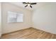 Bedroom with a ceiling fan, a window with blinds, wood-look flooring, and neutral wall paint at 10282 Country Flats Ln, Las Vegas, NV 89135