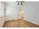 Bedroom featuring wood-look floors, window with blinds, double door closet and adjacent hallway with storage at 10282 Country Flats Ln, Las Vegas, NV 89135